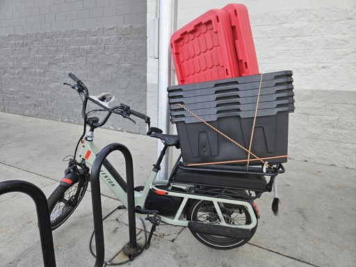 a cargo ebike loaded down with six big storage containers